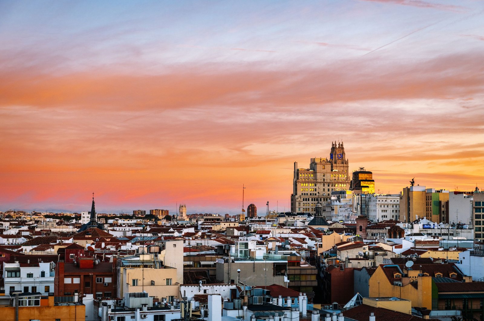 Breathtaking view of Madrid's skyline at sunset showcasing iconic architecture and vibrant sky.