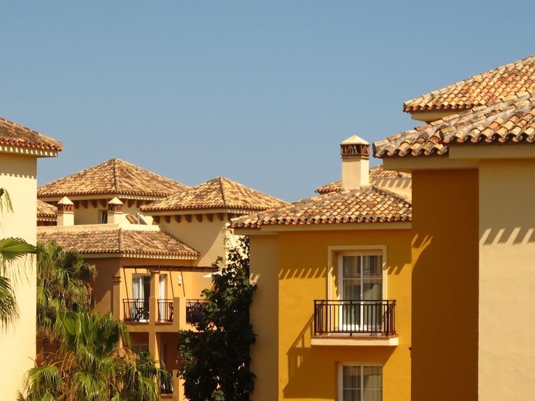 Charming yellow houses with gable roofs under the Andalusian sun in Marbella, Spain.