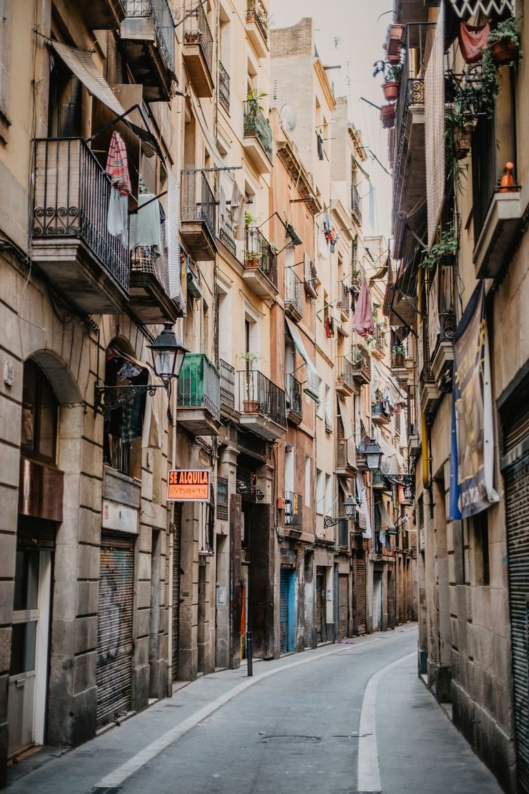 Picturesque narrow street in Barcelona showcasing historic architecture and vibrant balconies.